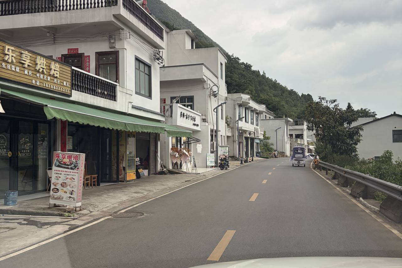 A Wanfenglin valley village street lined with small food shops and stalls